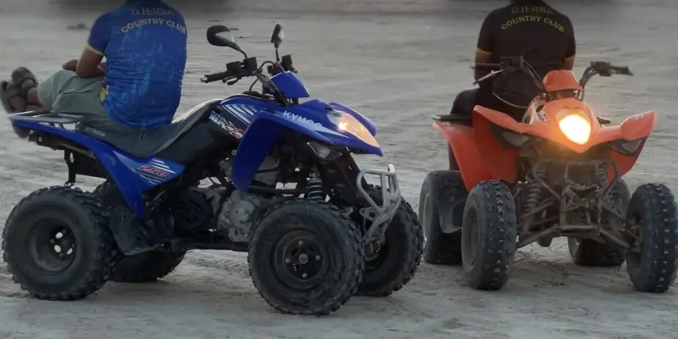 Deux quads du club sur le sable au coucher du soleil